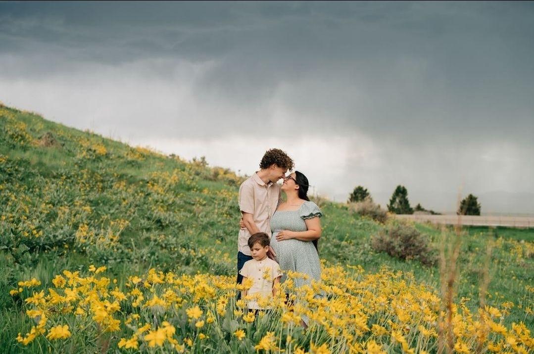 Jack and Eliza Lawrence stand with their son during a maternity photo shoot